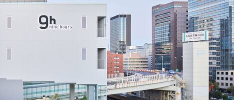 A modern building with a sign reading '9h nine hours' and another sign for 'Be Green'.