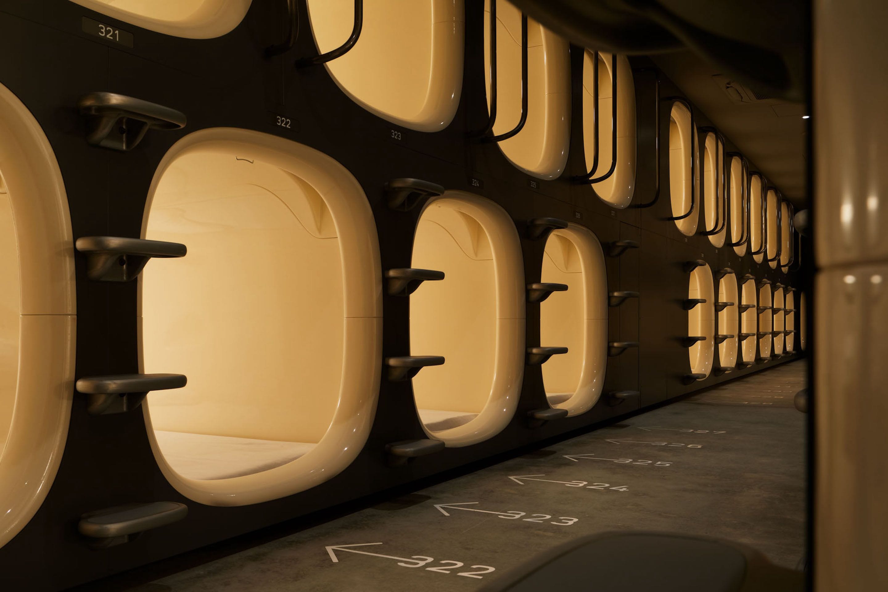 A row of airplane lavatories with numbered doors and a directional arrow on the floor.