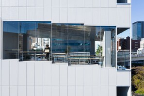 A modern building with large glass windows, outdoor seating, and a view of the cityscape. - 9h nine hours Suidobashi (Tokyo)