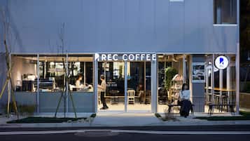 Un café avec une enseigne bien visible, des tables à l’extérieur et un menu affiché de manière claire.
