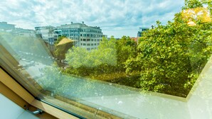 A view through a window with reflections of buildings and trees.