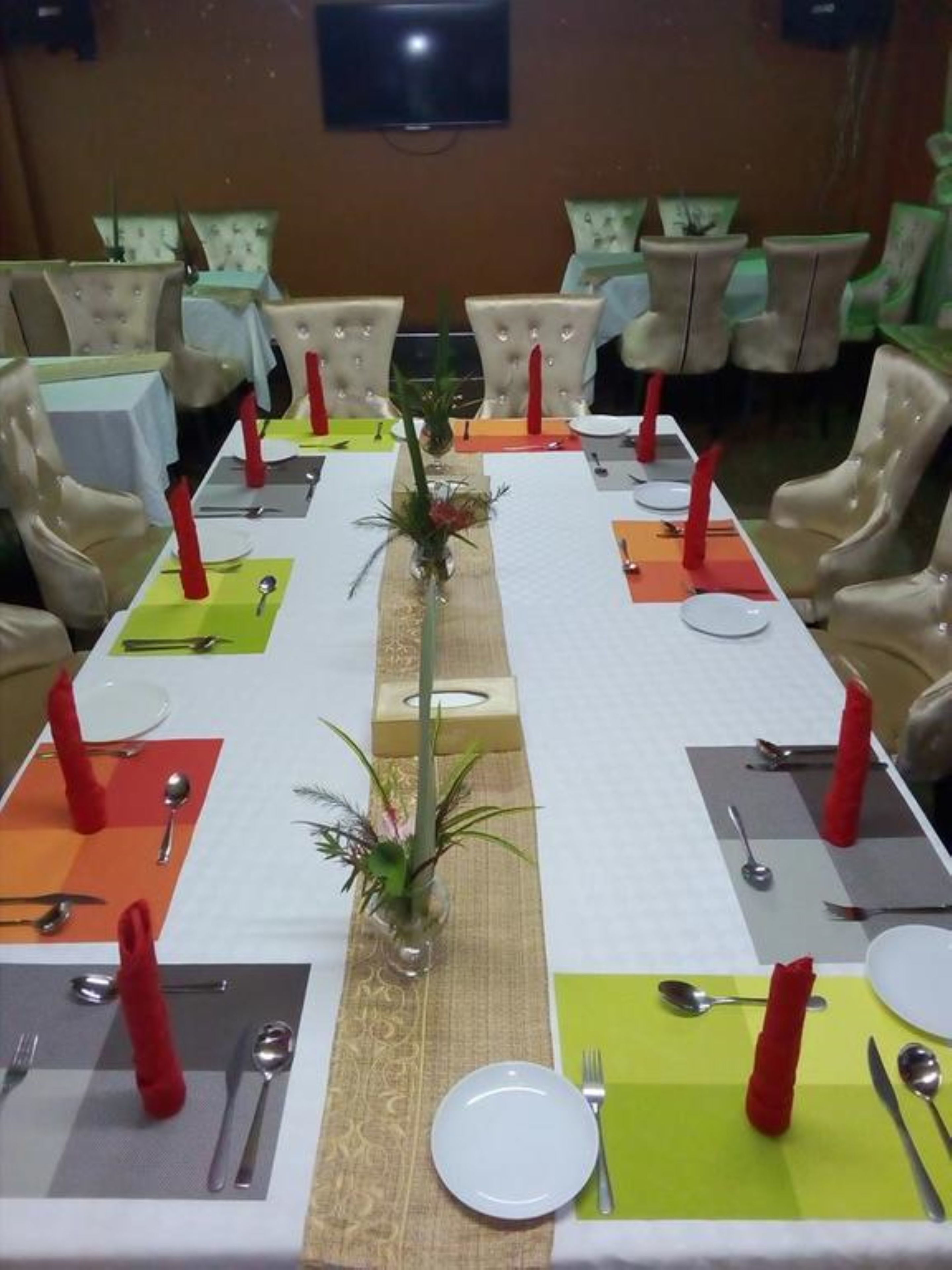 A conference room with a long table set for a meeting, surrounded by chairs.