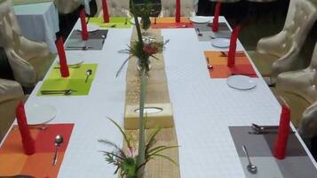 A conference room with a long table set for a meeting, surrounded by chairs.