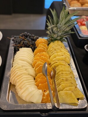 A buffet tray with sliced fruits and a pineapple. - Calamar Hotel (São Vicente)