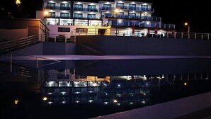 A multi-story hotel with balconies and a pool area. - Calamar Hotel (São Vicente)