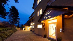 Entrada de un hotel con un cartel bien iluminado que dice 'Hotel Eining'.