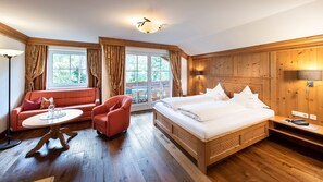 Une chambre d’hôtel avec un lit, un canapé, une chaise, une table et une fenêtre.