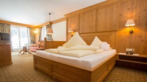 Una stanza con rivestimento in legno, un letto grande, una televisione e una lampada.