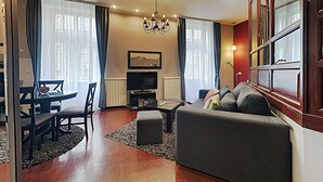 Un salon comprenant un canapé, un téléviseur et un coin repas.