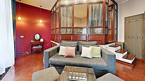 Un salon confortable avec un canapé, une table basse et une grande fenêtre agrémentée de rideaux.