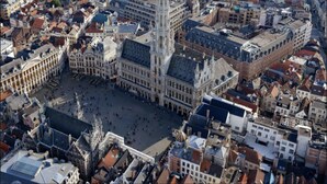 A historic city square surrounded by traditional European architecture, including a prominent cathedral and a tall, ornate building. - White Studio (Brussels)