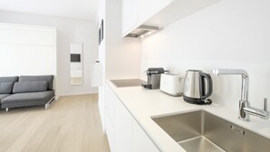 A modern kitchen with a stainless steel sink, a kettle, and a toaster. - White Studio (Brussels)