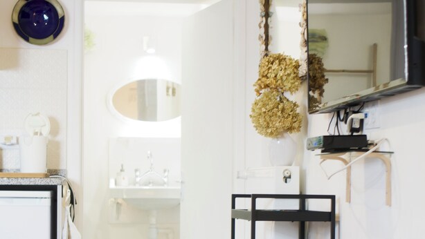 Un bagno moderno con un lavandino bianco, un mobile bagno nero e uno specchio.