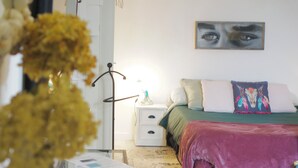 Una camera da letto con un letto, un comodino, una lampada e un quadro appeso al muro.