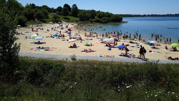 A beach with people sunbathing and swimming, surrounded by greenery and a clear sky. - Chambre d'Hôtes La Bastide de Villenave (Villenave)