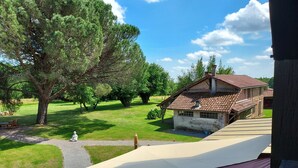 A rustic house with a tiled roof, surrounded by a grassy area and trees. - Chambre d'Hôtes La Bastide de Villenave (Villenave)