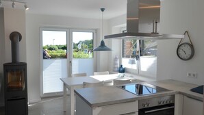 Eine moderne Küche mit Herd, Backofen und Essbereich.