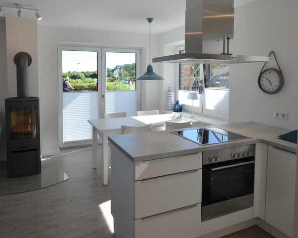 A modern kitchen with a stove, oven, and dining area.