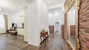 A spacious room with a wooden floor, a large mirror with an ornate frame, and a brick wall. - Royal Apartment Zagreb (Zagreb)