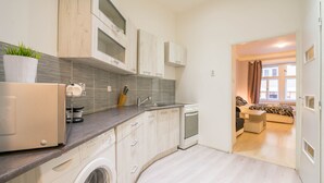 Une cuisine compacte équipée d’un lave-linge, d’un four à micro-ondes et d’un évier.