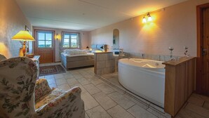 A spacious bathroom with a large bathtub, a separate shower area, and a vanity with a mirror.