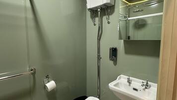 A bathroom with a toilet, a sink, and a shower.