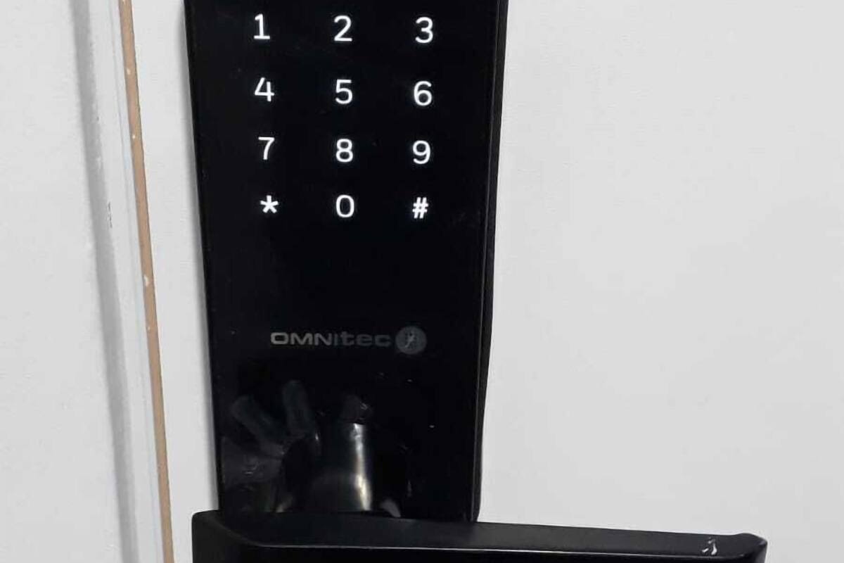A black electronic keypad mounted on a white door, with a key slot below it.
