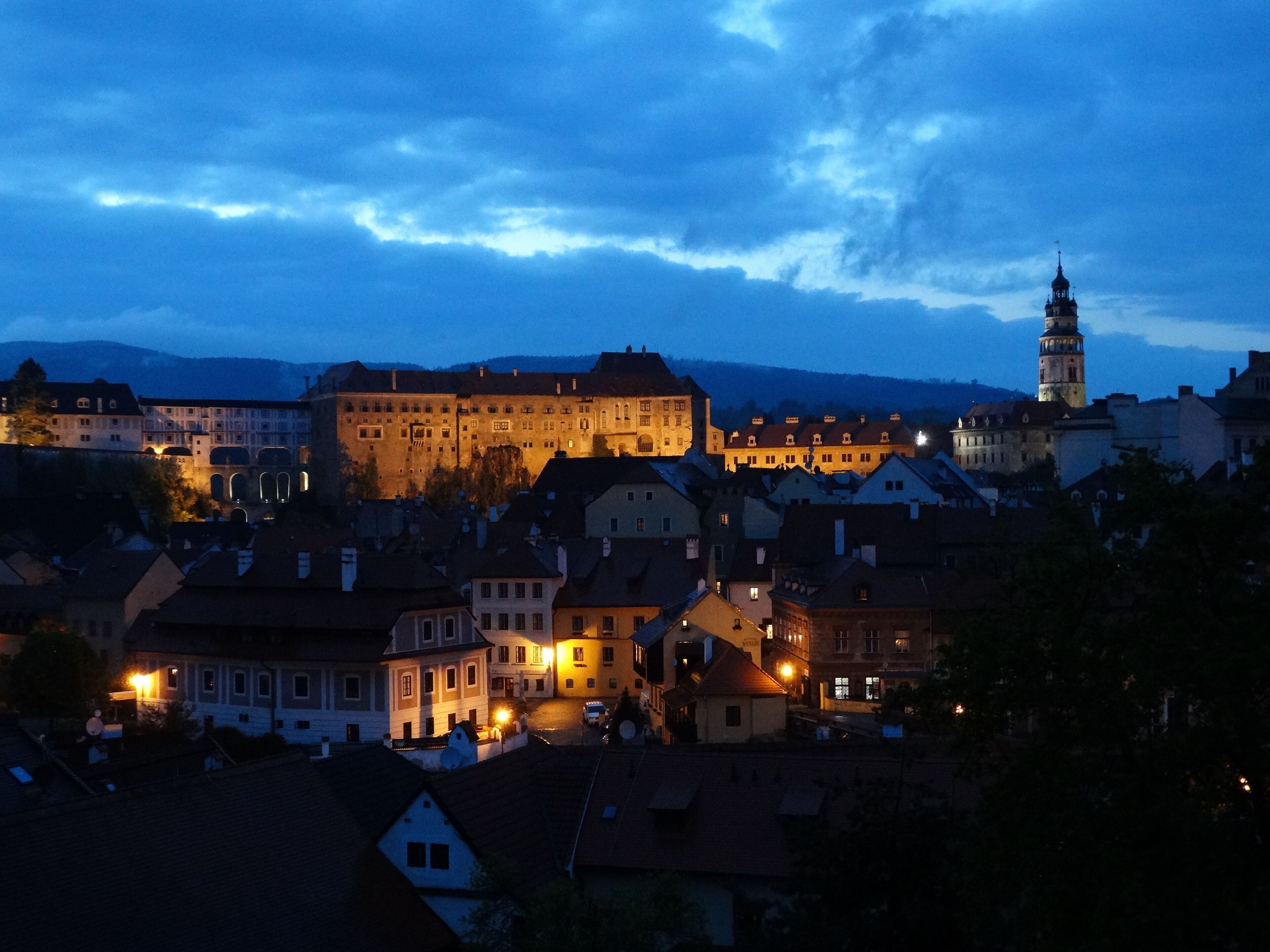 A historic town with a prominent castle-like building and a tall tower, surrounded by traditional European architecture.