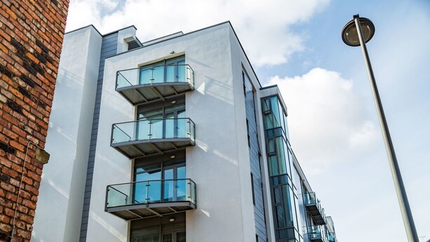 Um edifício moderno com várias varandas e janelas amplas.