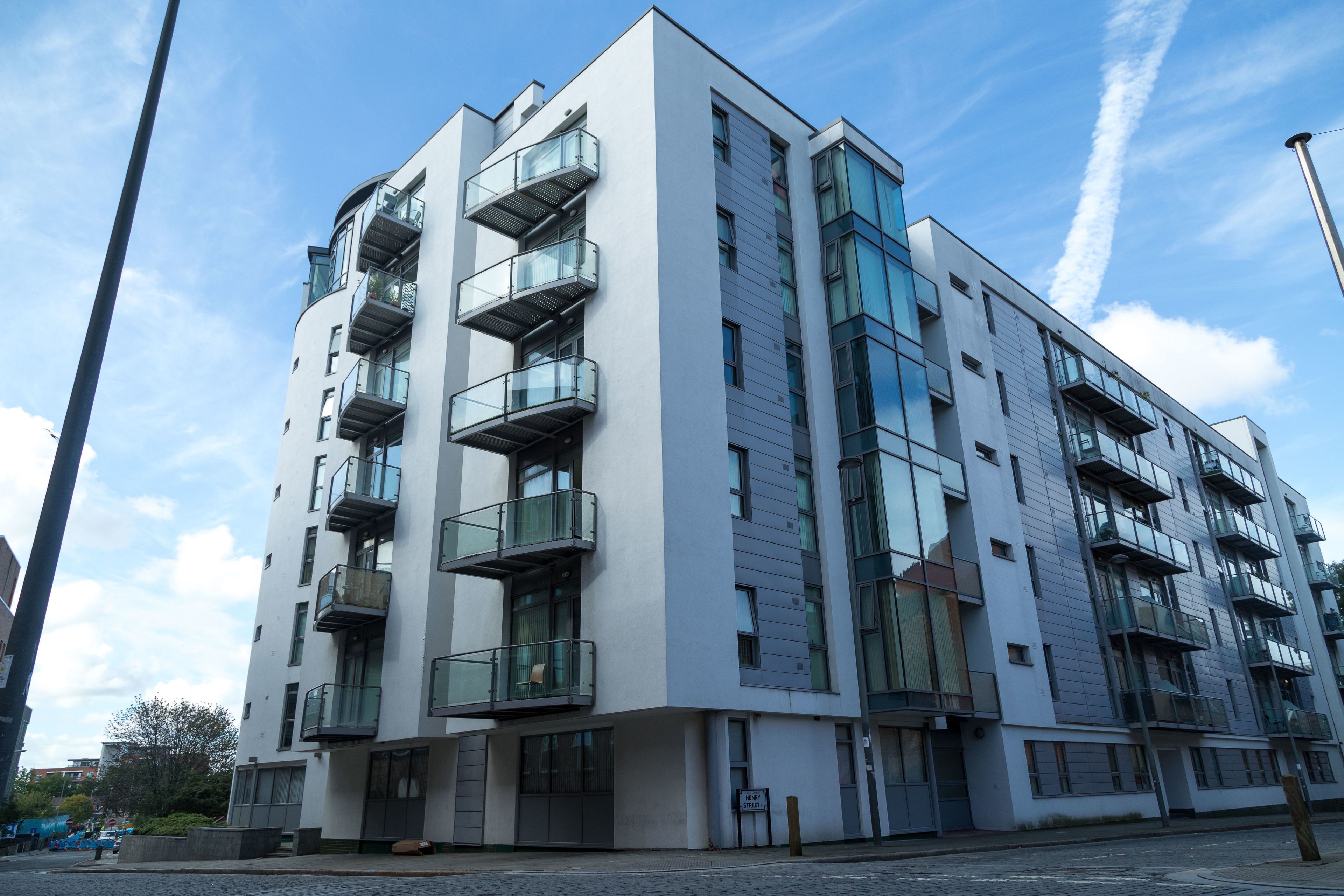 A modern multi-story building with balconies and large windows.
