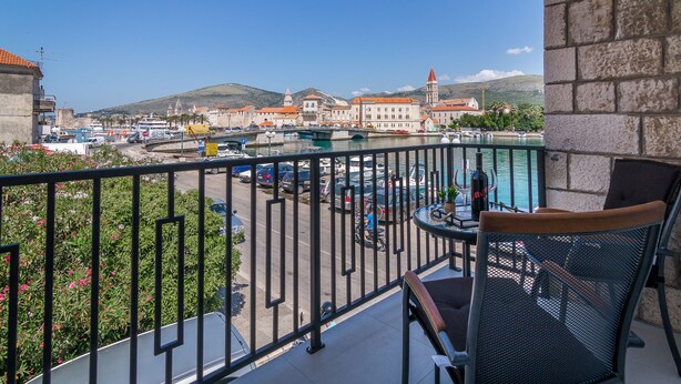 A balcony with a view of a marina, a dining area with a table and chairs, and a stone wall. - 4 Elements Old Town Views Rooms (Trogir)