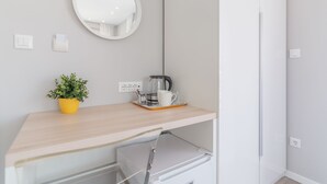 A modern bathroom with a wooden vanity, a round mirror, a potted plant, and a coffee maker. - 4 Elements Old Town Views Rooms (Trogir)