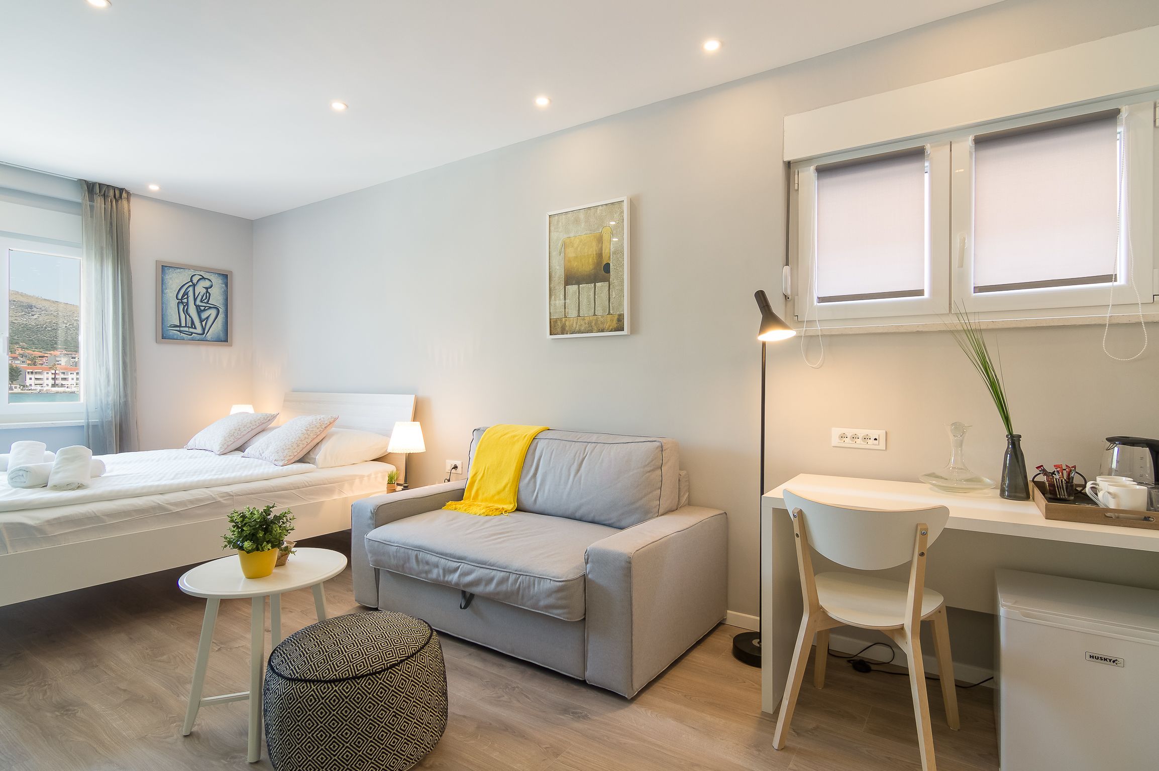 Une chambre moderne comprenant un lit, une table de chevet et un petit espace bureau avec une chaise.
