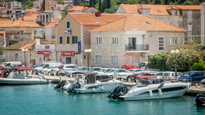 A marina with boats docked, surrounded by buildings with red-tiled roofs and stone facades. - 4 Elements Old Town Views Rooms (Trogir)