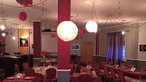 A restaurant with red and white checkered flooring, red chairs, and tables set with white tablecloths. - Hostel Restaurant Leyvamar (Guadahortuna)