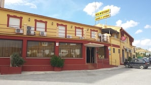 A yellow building with a sign indicating it is a hostel and restaurant. - Hostel Restaurant Leyvamar (Guadahortuna)