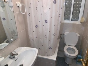 A bathroom with a bathtub, toilet, and sink. - Hostel Restaurant Leyvamar (Guadahortuna)