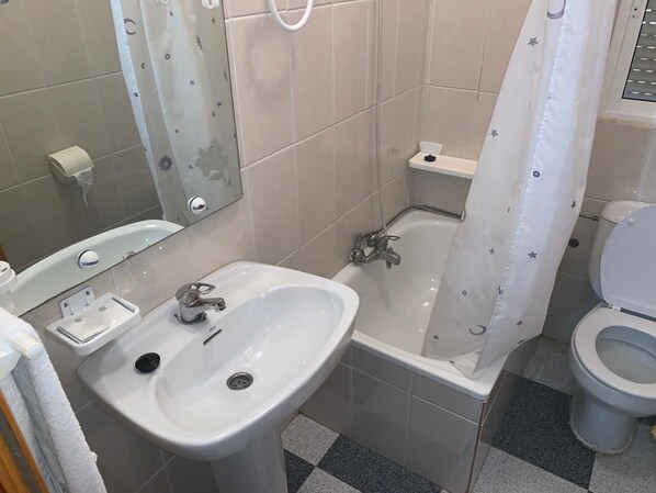 A bathroom with a sink, bathtub, toilet, and a shower curtain with star patterns. - Hostel Restaurant Leyvamar (Guadahortuna)