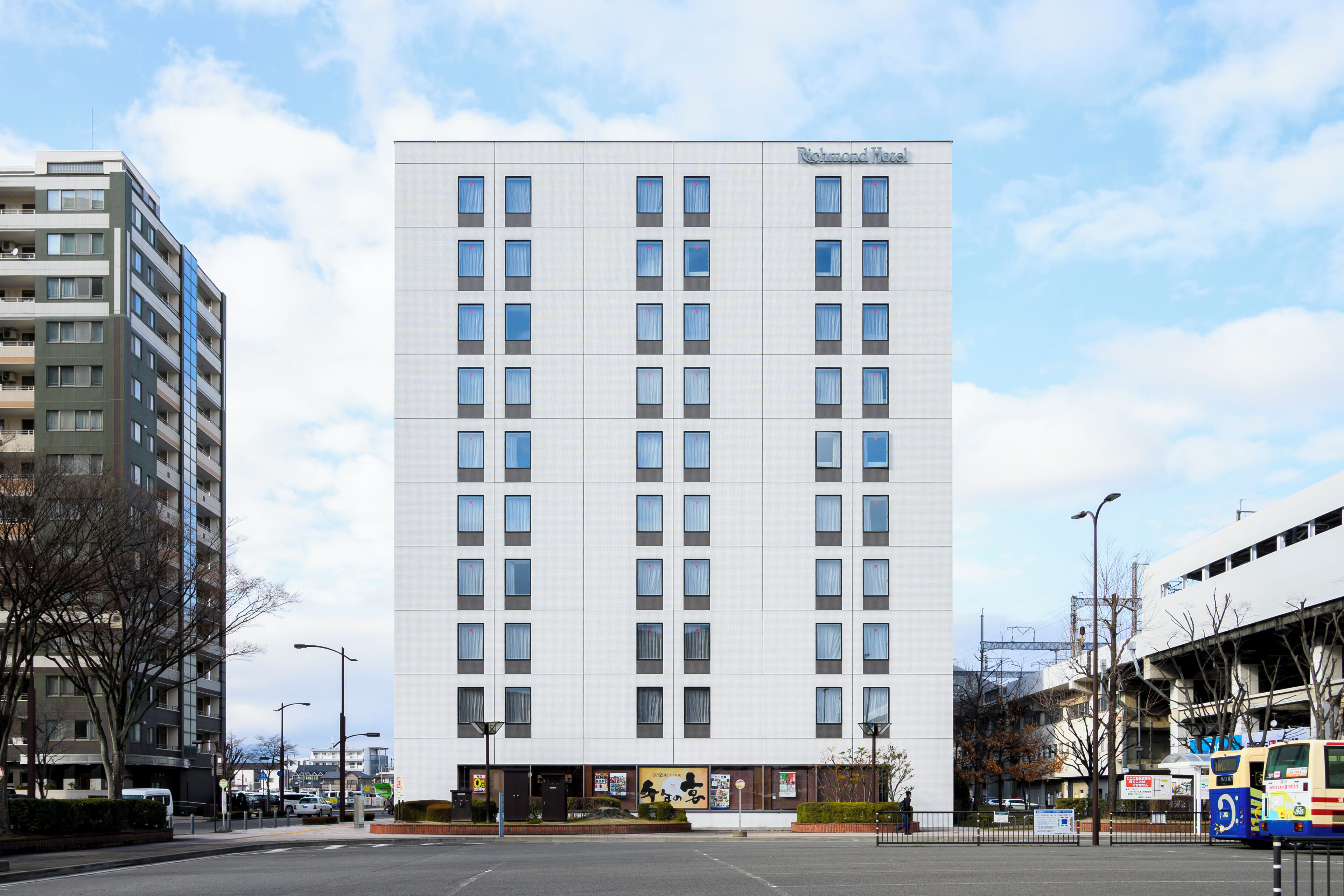 A modern hotel with a central entrance, multiple floors, and a flat facade.