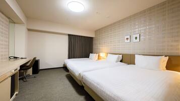 A hotel room with two beds, a desk, a chair, and a large mirror.