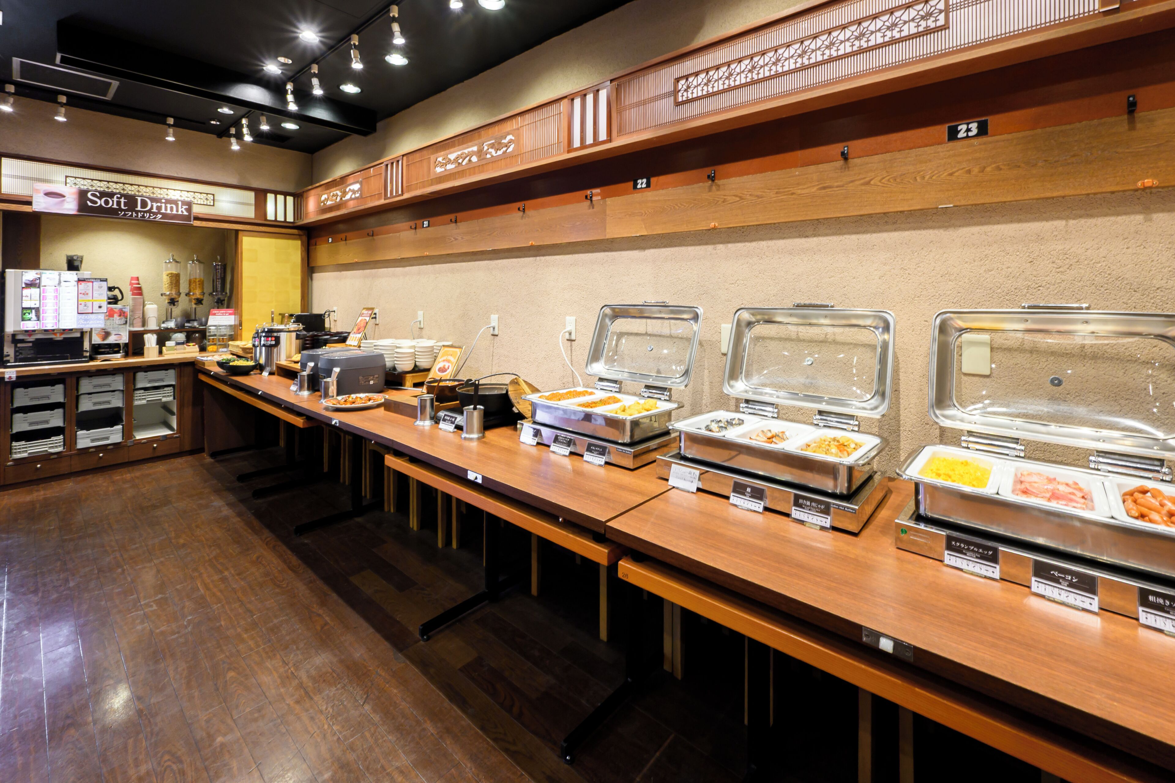 A buffet area with multiple food stations, a coffee machine, and a soft drink sign.