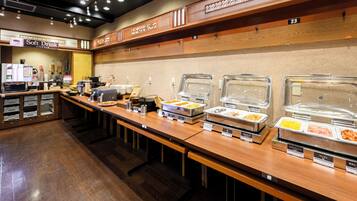 A buffet area with multiple food stations, a coffee machine, and a soft drink sign.