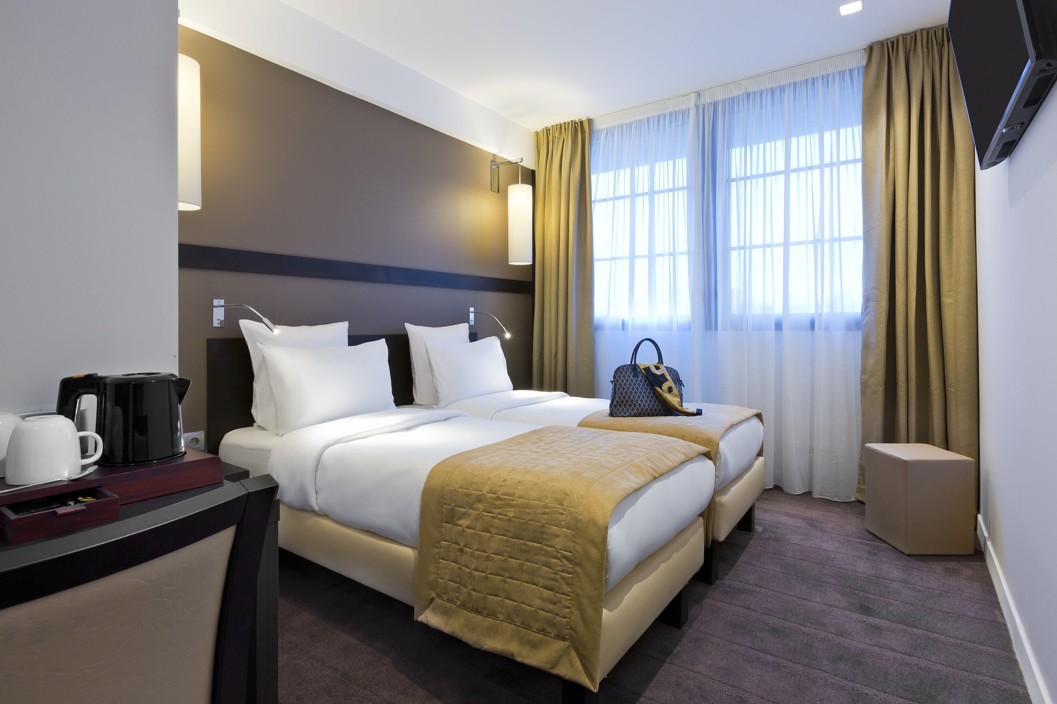 Una habitación de hotel con cama, mesita de noche y televisor.
