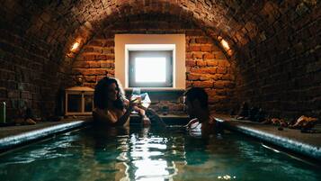 Relax in a, arched bath with a window for natural light and a low, tiled edge.