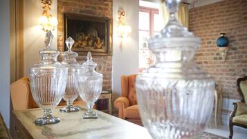 Um quarto com uma mesa exibindo vasos de vidro transparente, uma parede de tijolos e um quadro na parede.