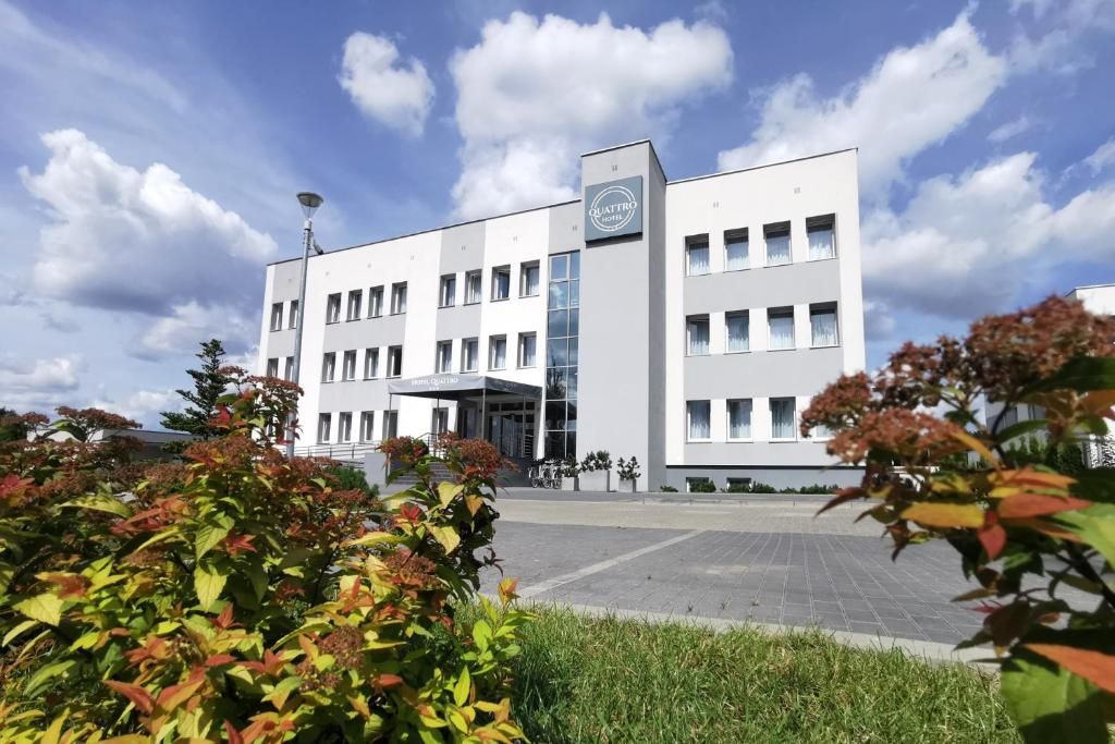 A modern hotel building with a flat roof, multiple windows, and a prominent entrance.