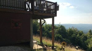 A wooden deck with a view of a mountainous landscape.