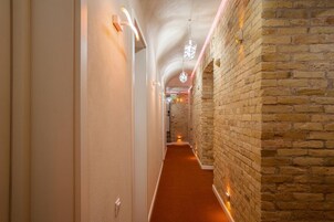 A hallway with a brick wall and a carpeted floor.