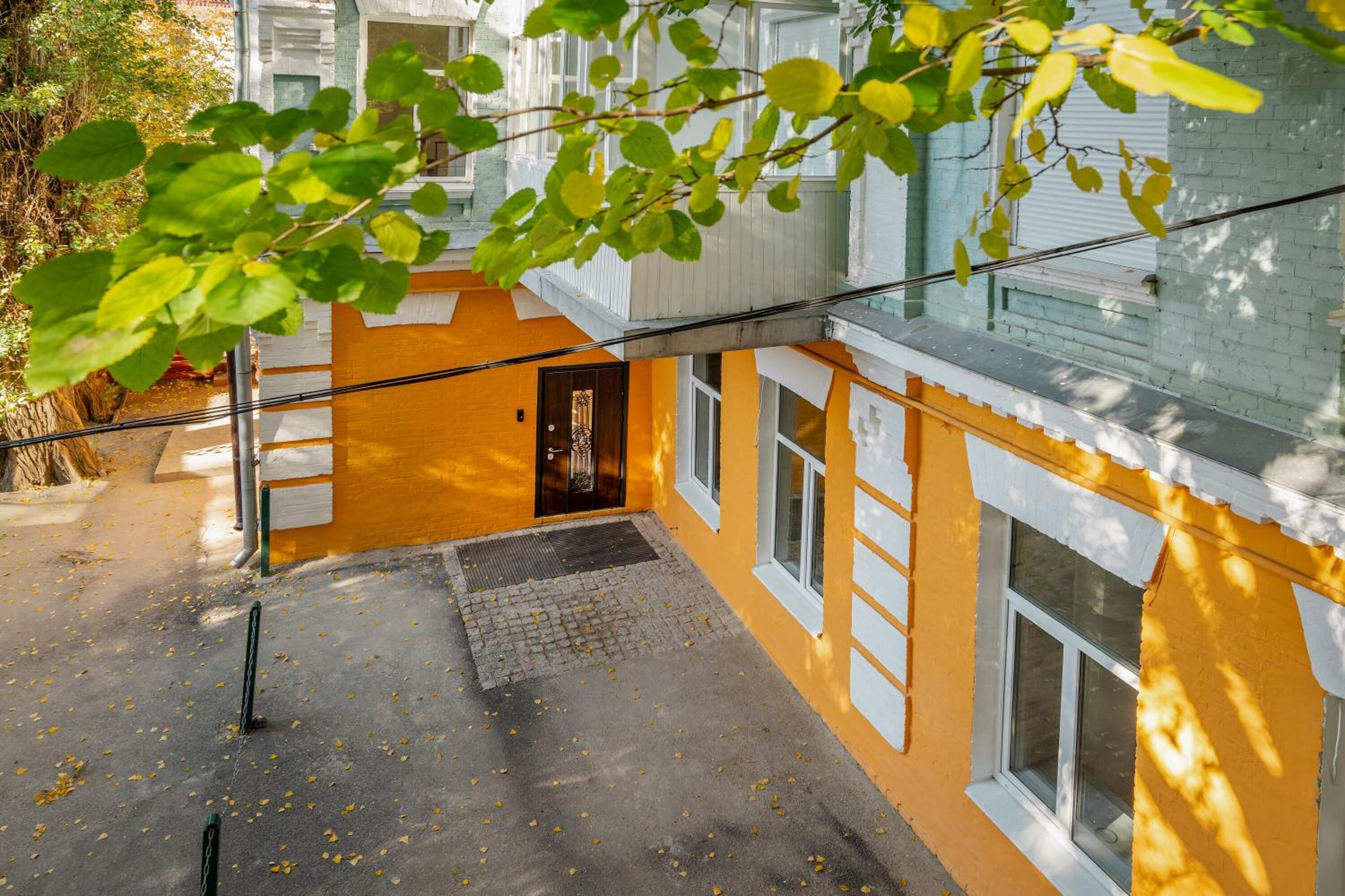 A yellow building with a small entrance and a window.