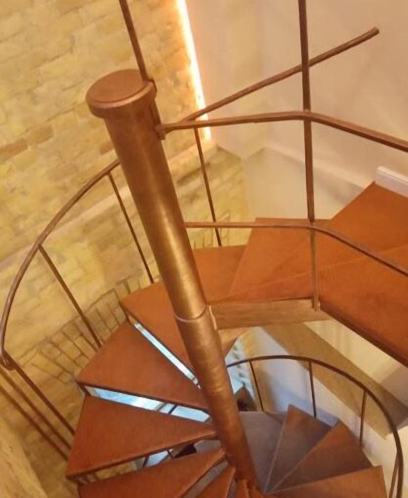 Eine Wendeltreppe mit Metallgeländer und Holzstufen.